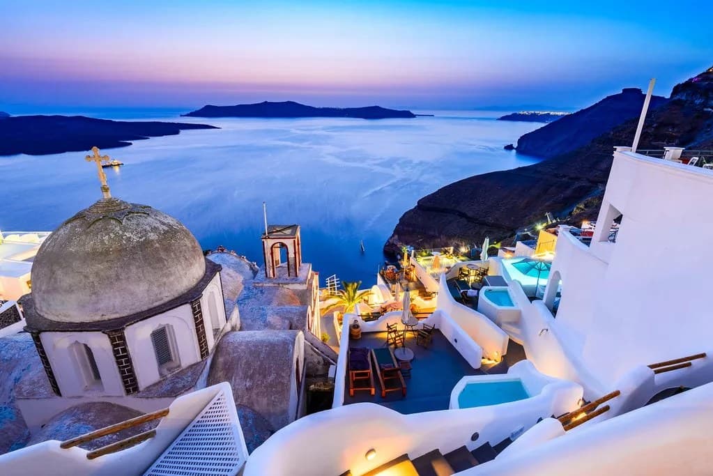 Santorini at dusk, whitewashed terraces above the caldera